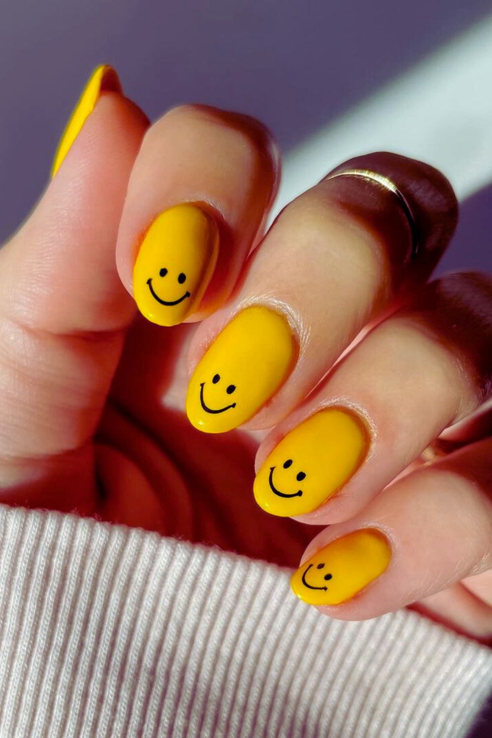 Bright yellow nails with black smileys