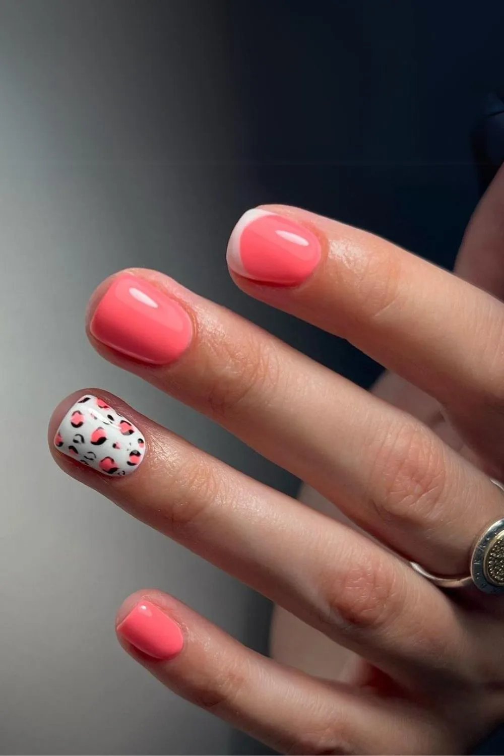 Coral pink nails with white leopard accent