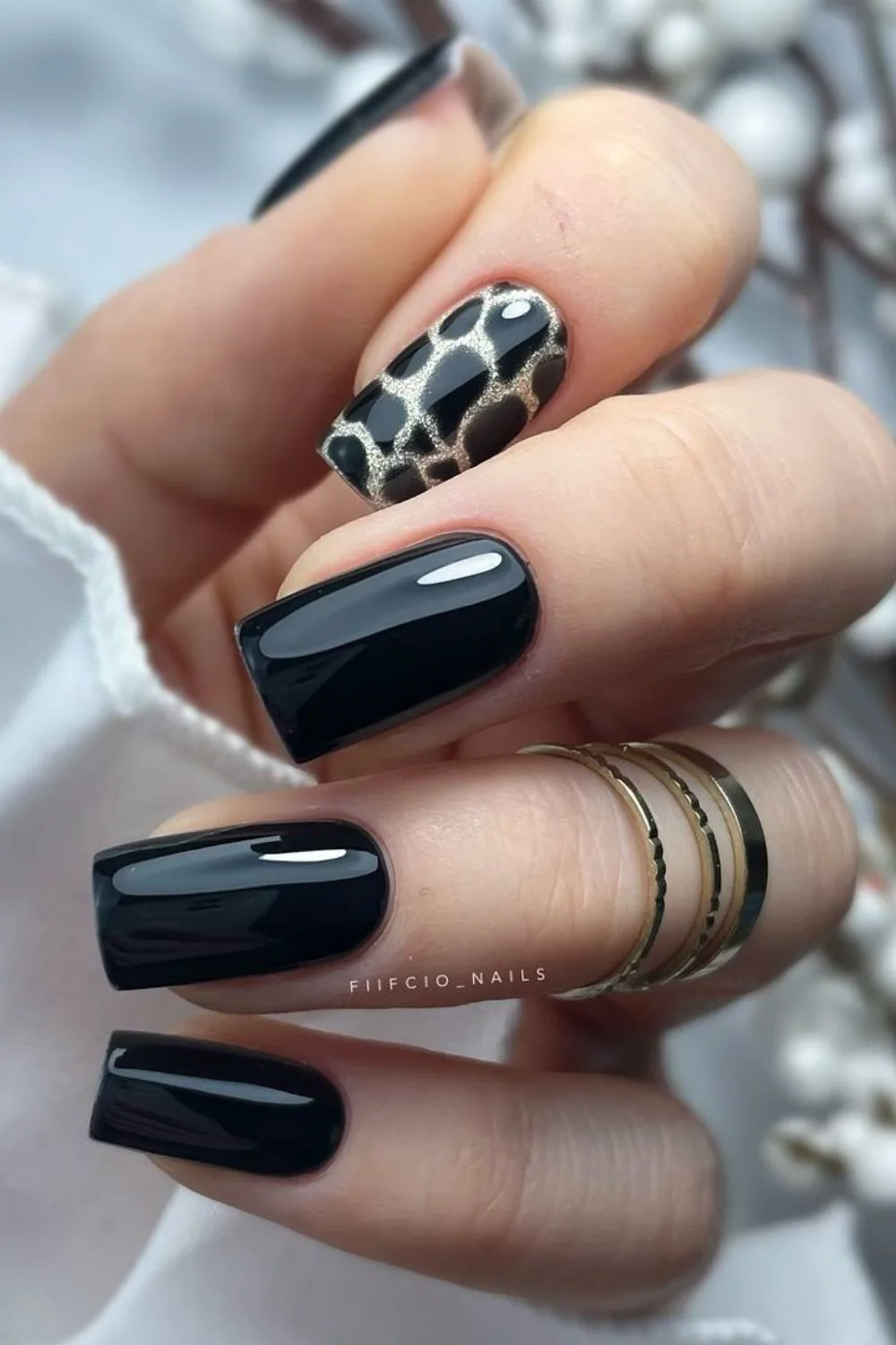 Glossy black nails with subtle leopard print