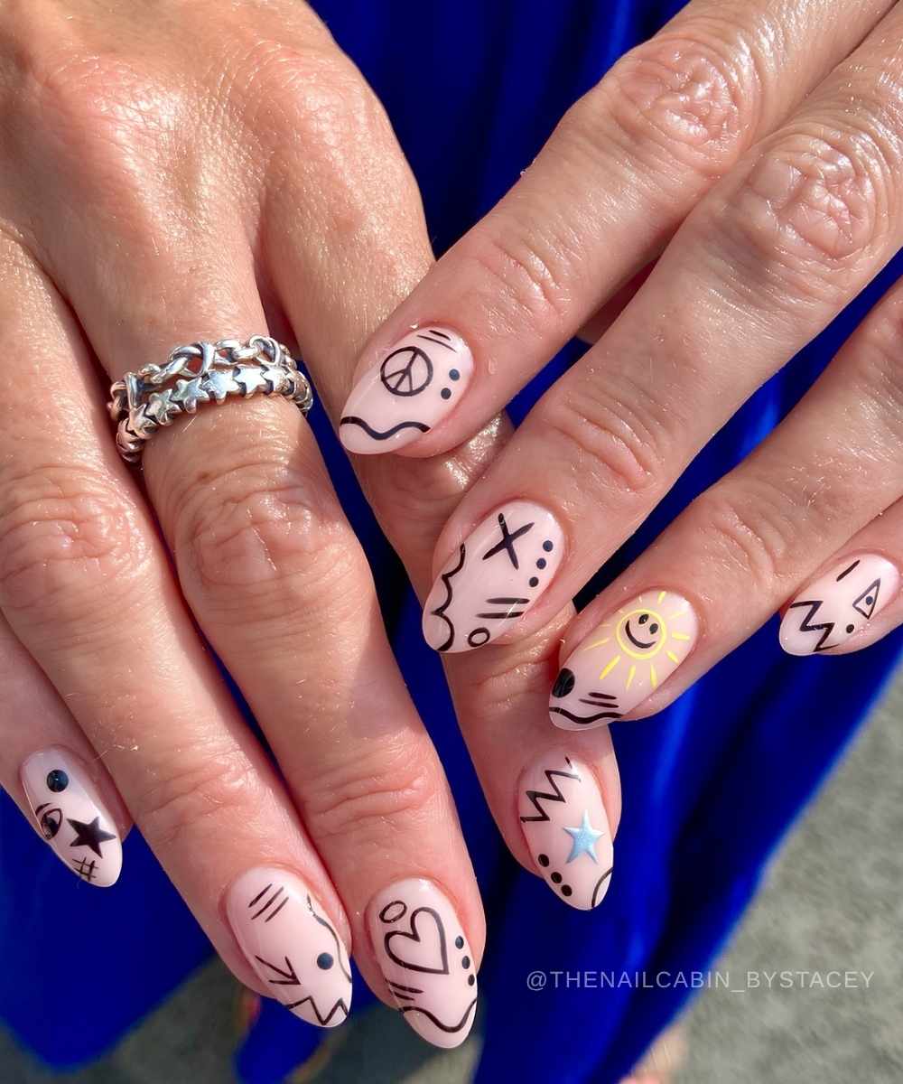Milky manicure with black and yellow doodle art