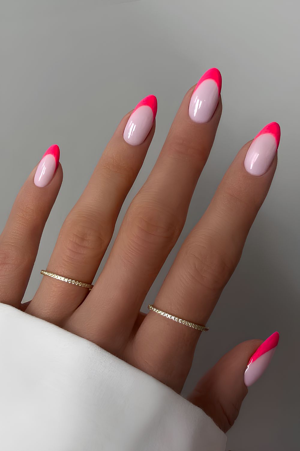 Neon pink French nails on a milky base