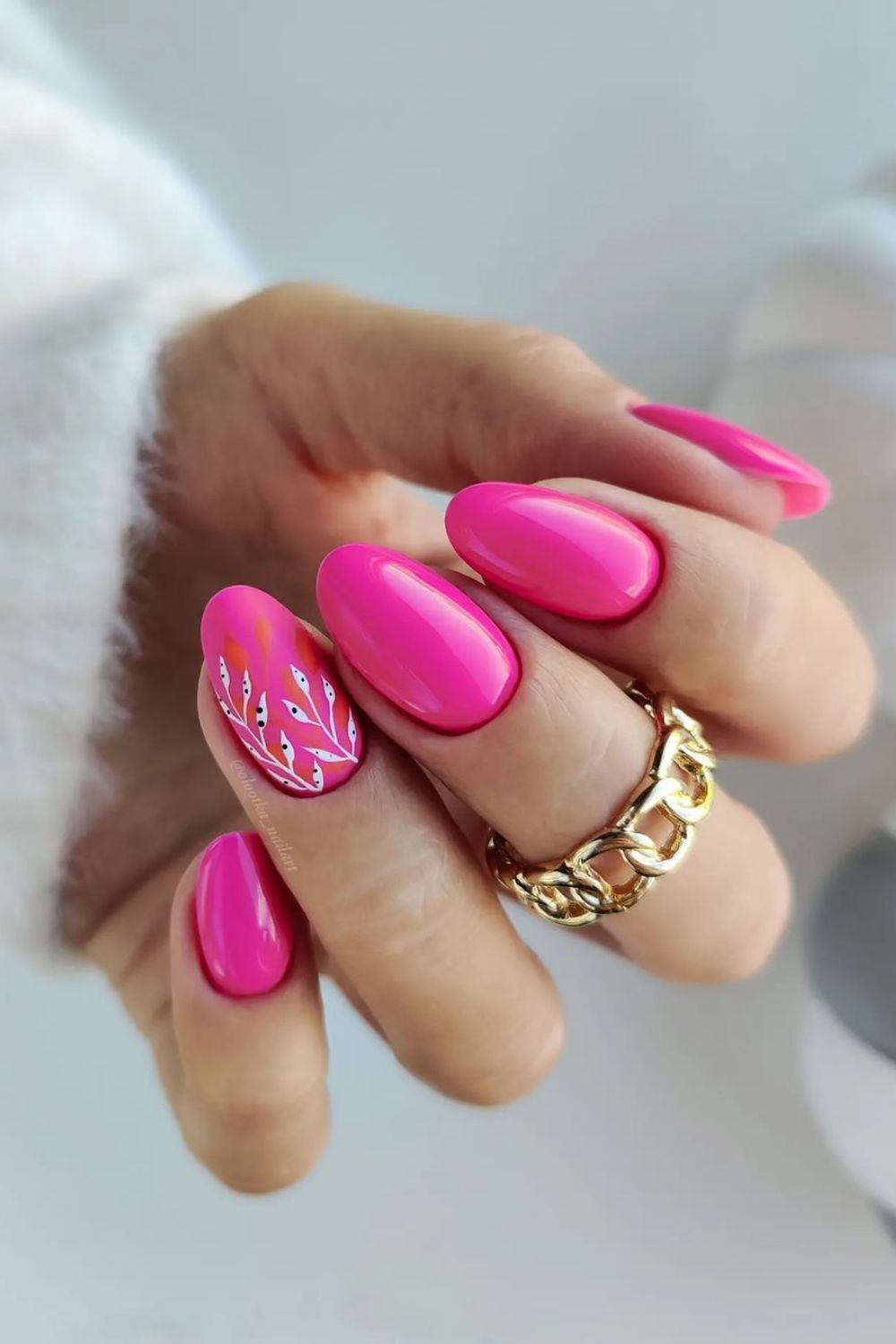 Neon pink nails with leafy accents