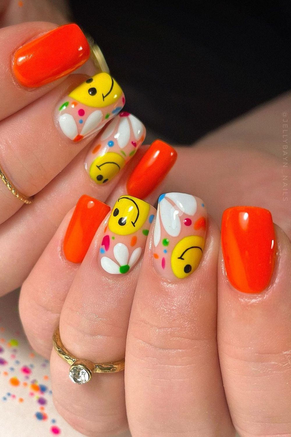 Orange nails with smileys and daisies