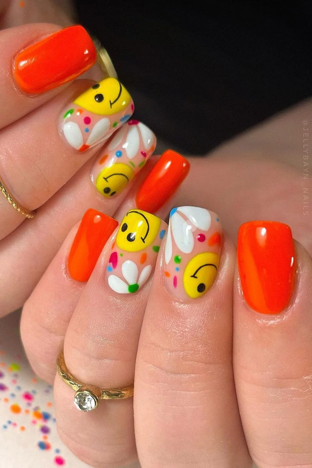 Orange nails with smileys and daisies