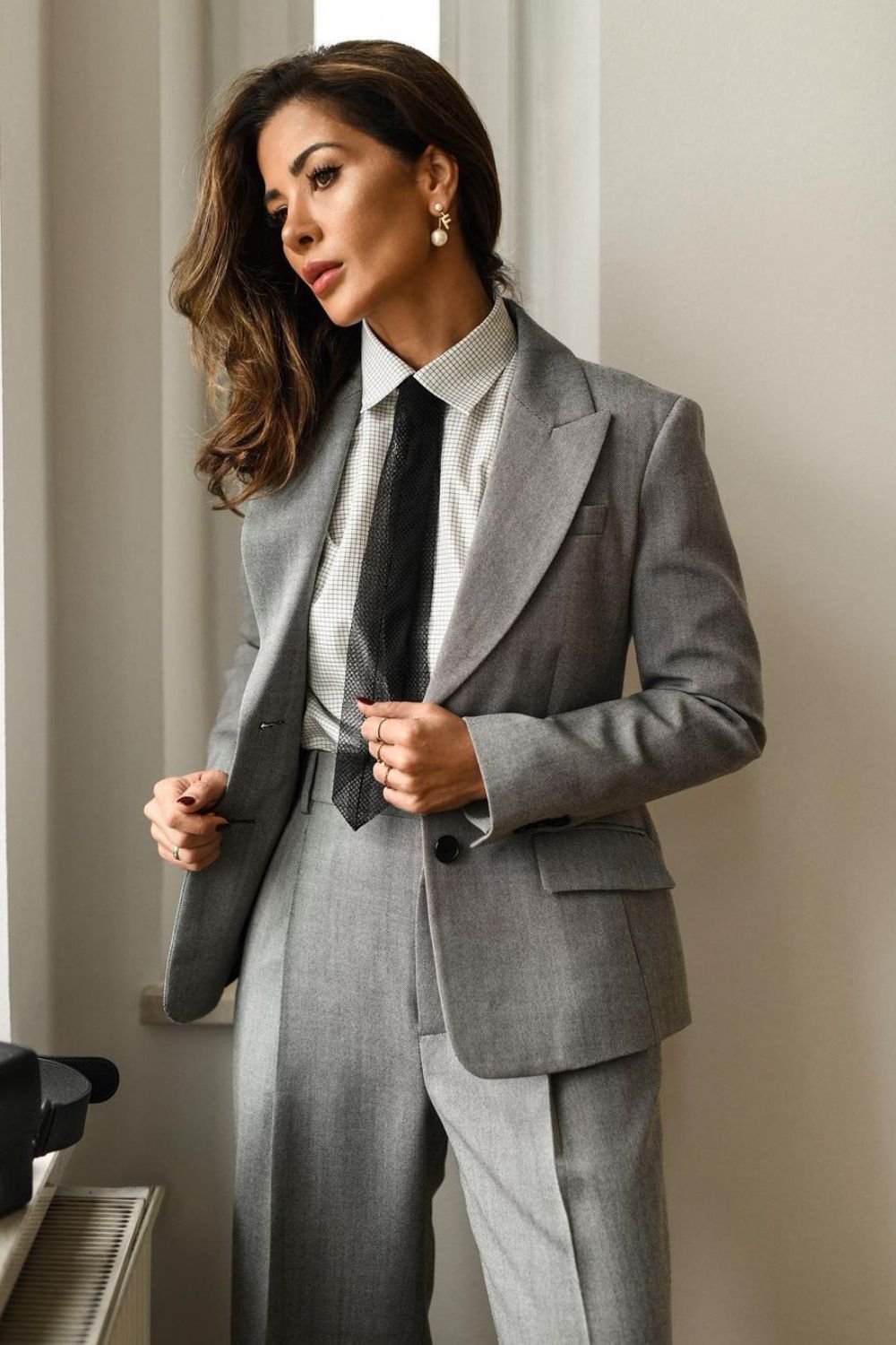 Woman in a grey suit with a black tie