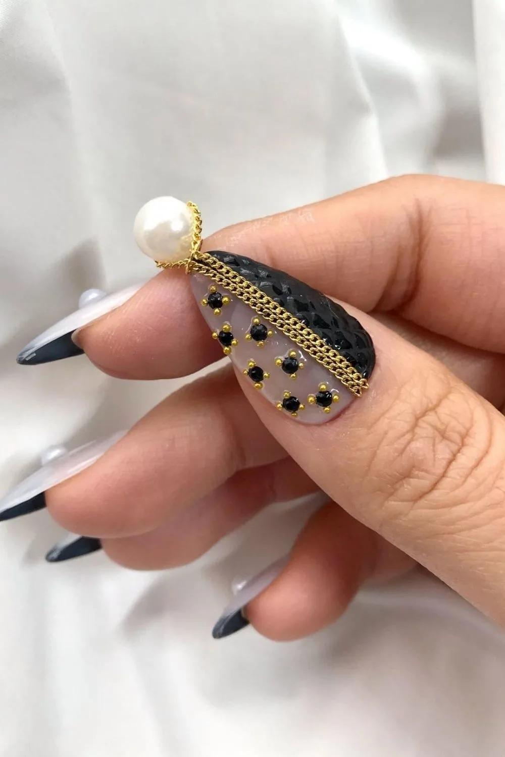 black and gold nails with white pearls