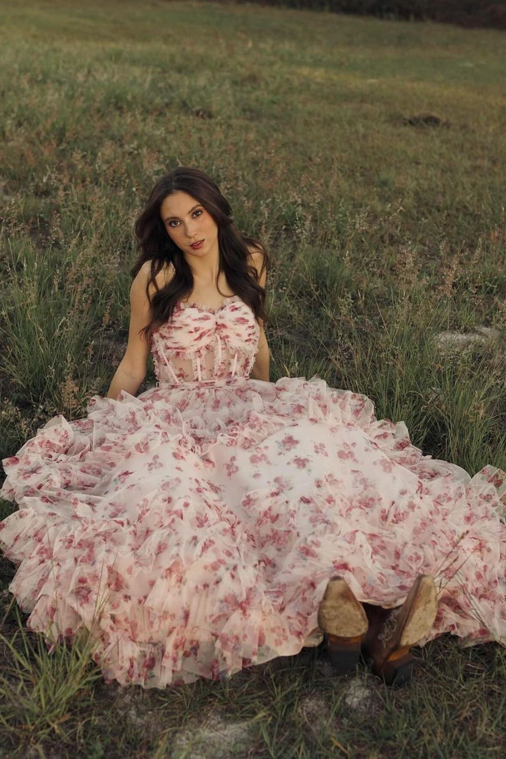 woman posing in a floral dress on the grass