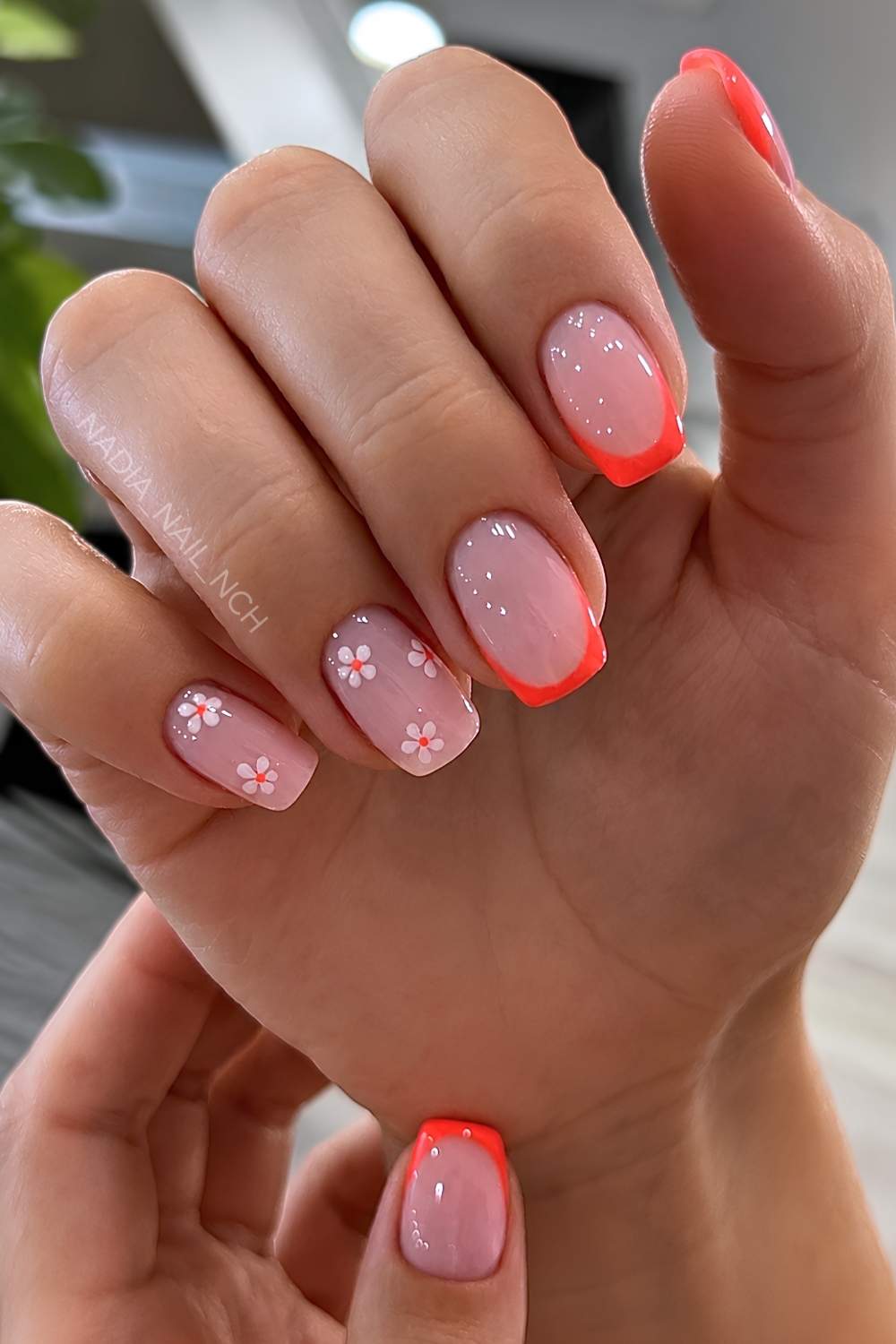 Neon orange French nails with micro flowers