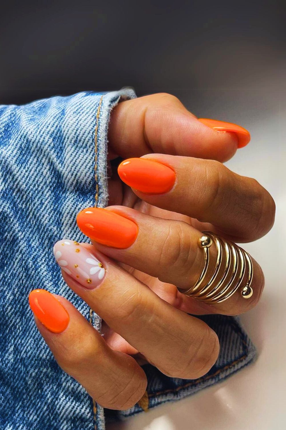 Neon orange nails with floral accent