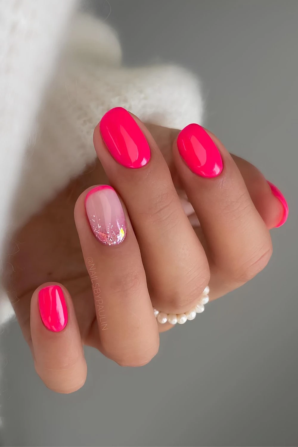 Neon pink short nails with glitter accent