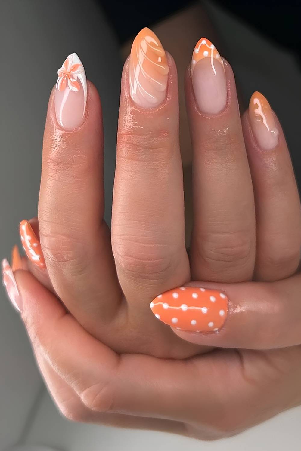 Orange nails with polka dots and flowers