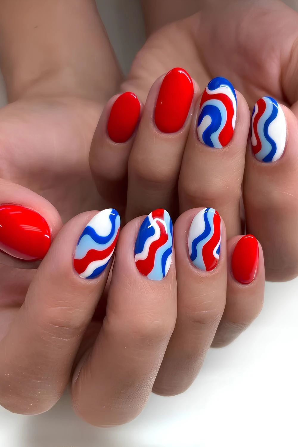 Red mani with blue and white accent swirls