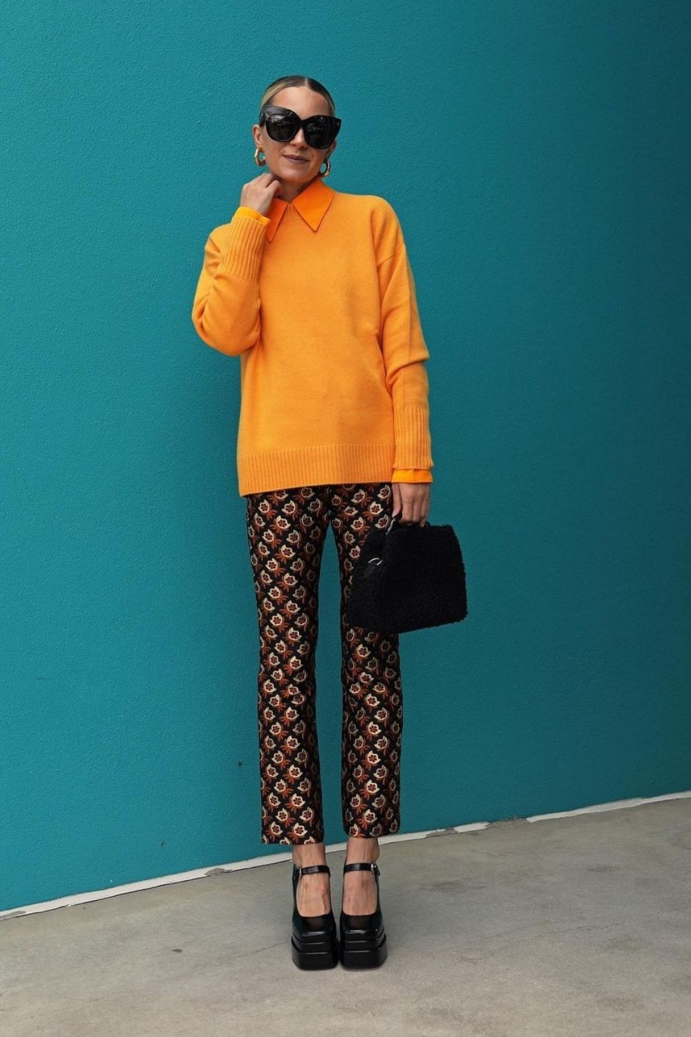 a model wearing orange shirt and pants in colorful pattern