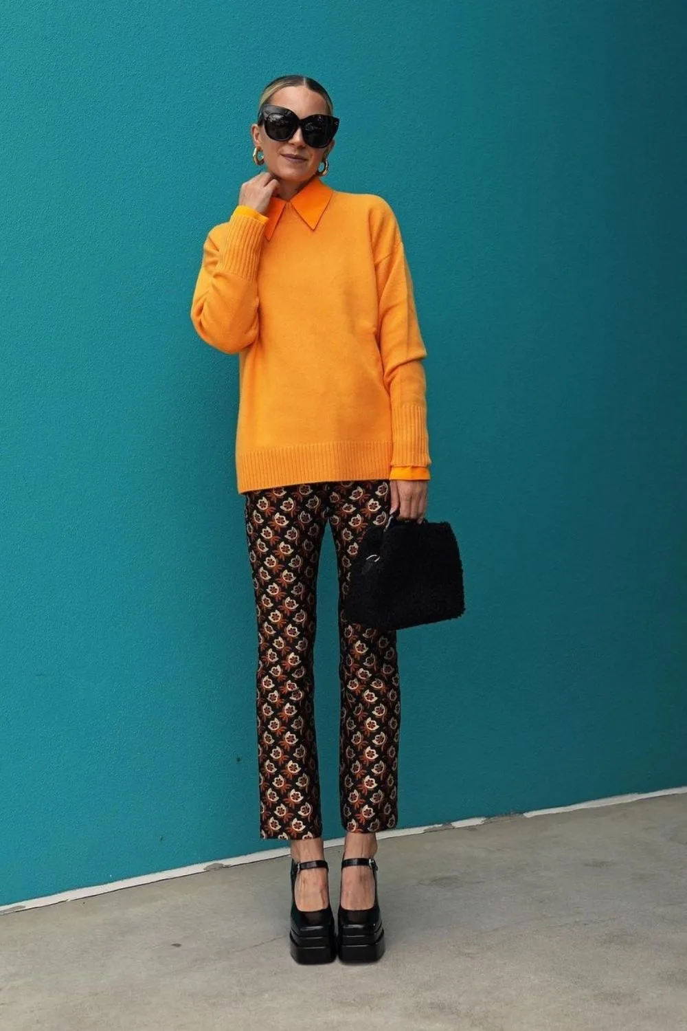 a model wearing orange shirt and pants in colorful pattern