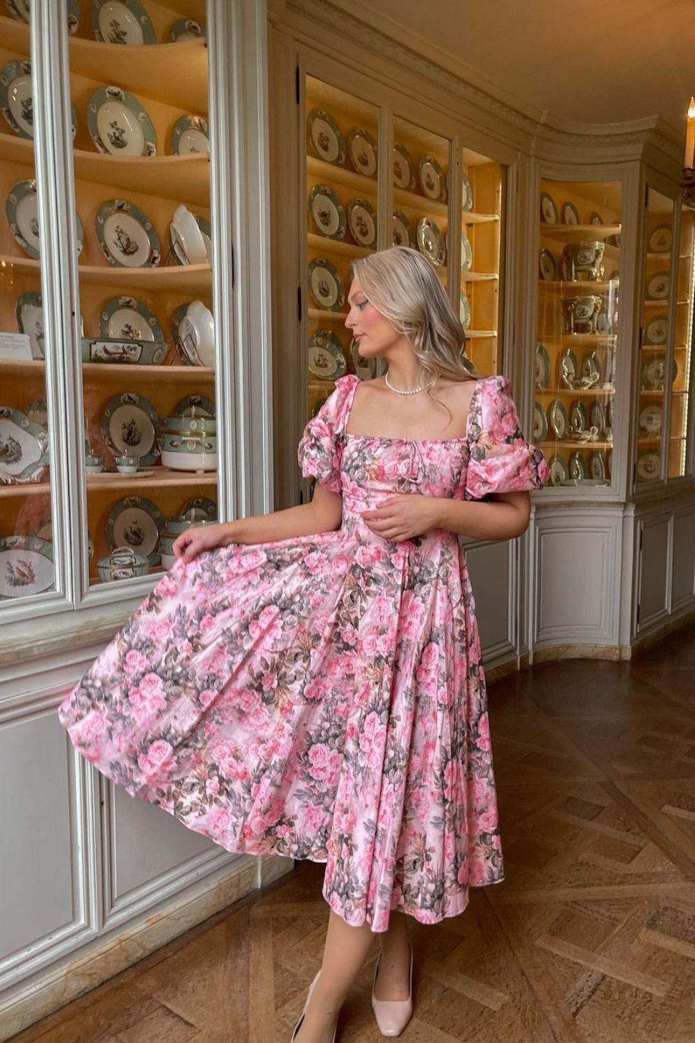 a woman in floral dress posing