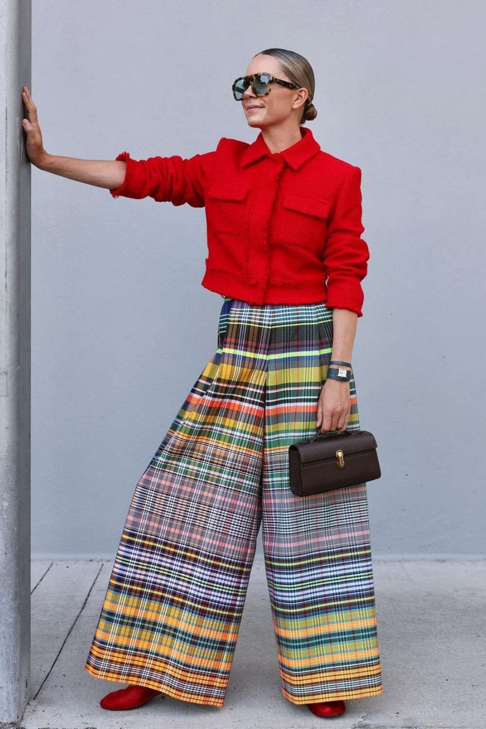 a woman wearing red jacket with colorful pants