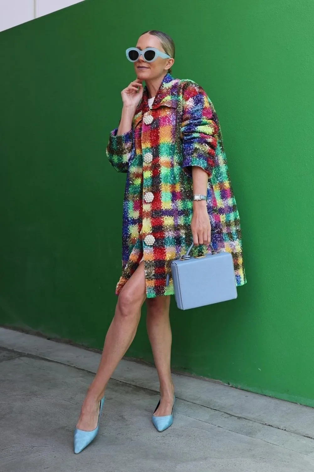 chic woman in a colorful dress with blue bag