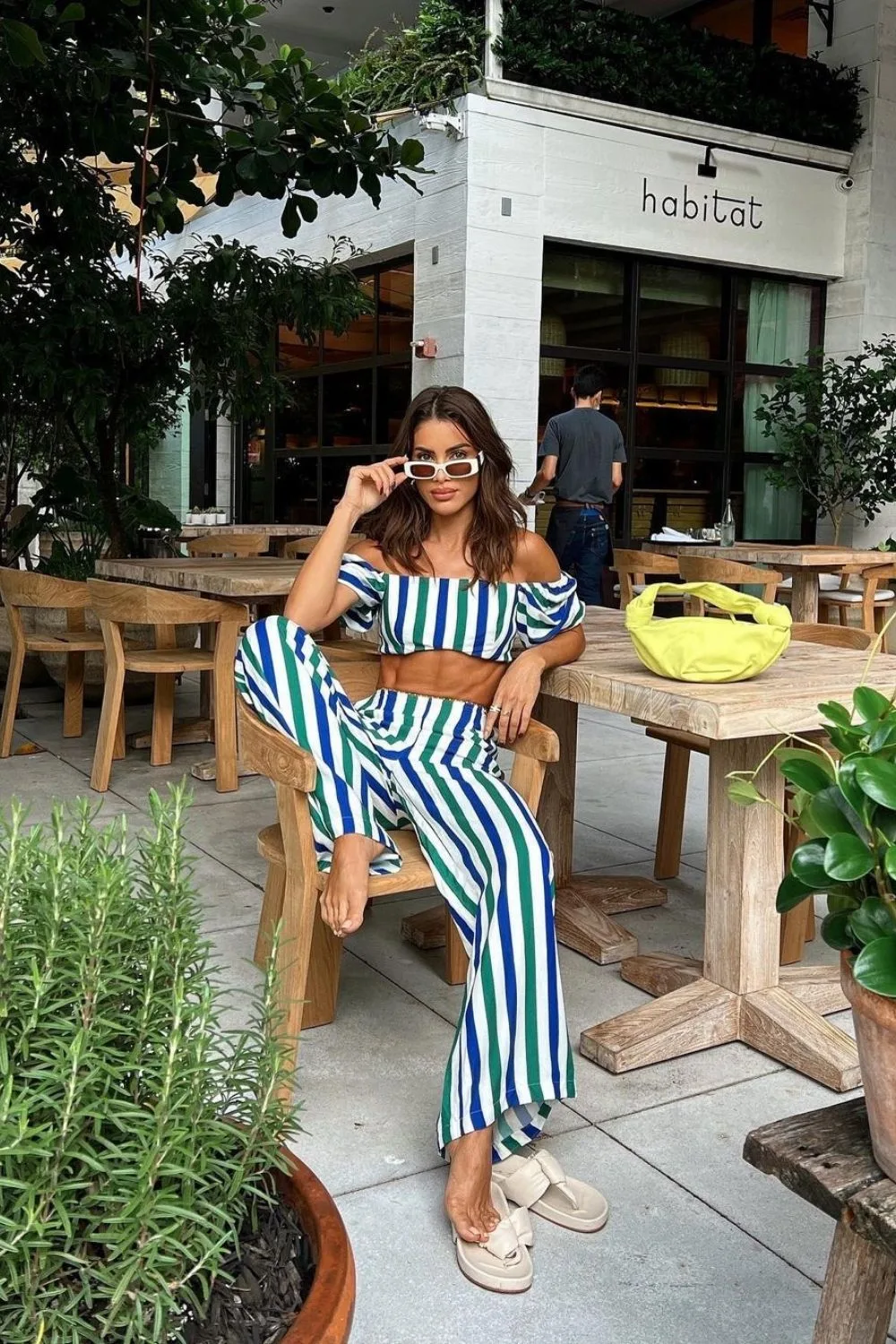 pretty woman sitting on the chair and posing in a stripe set