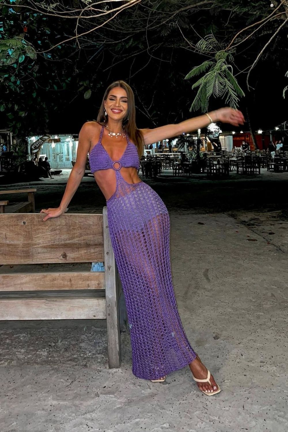 smiling woman posing in purple knitted dress