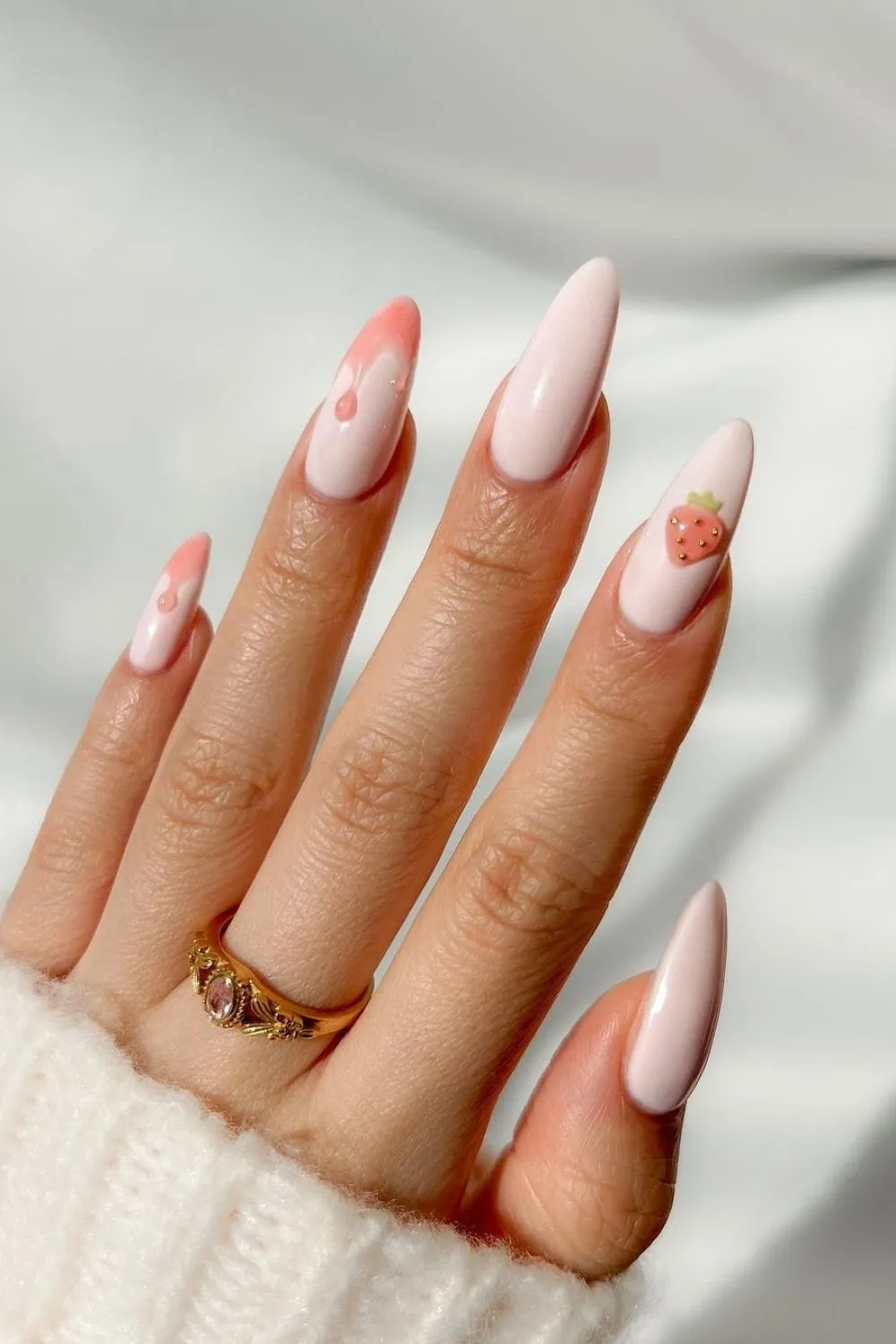 soft pink almond nails with a strawberry