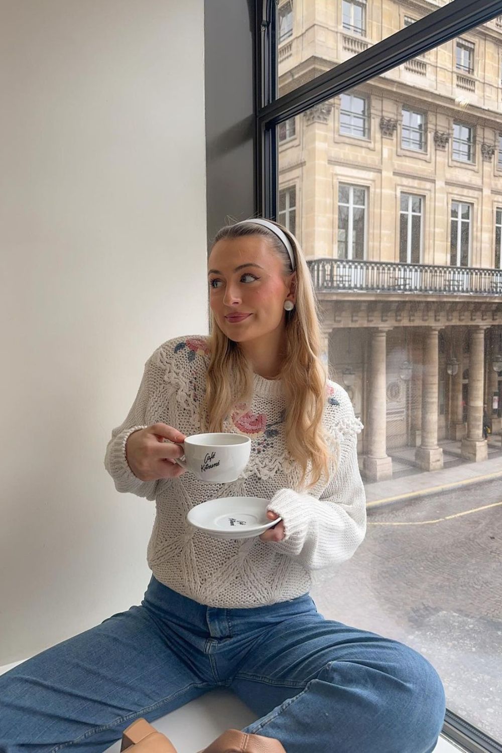 woman in sweater holding a cup