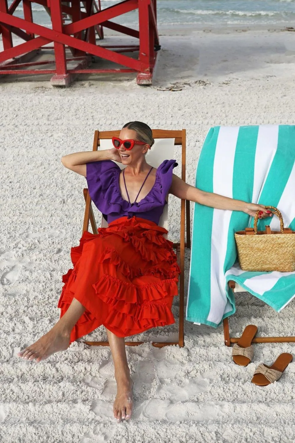 woman posing in a red maxi skirt and a purple shirt