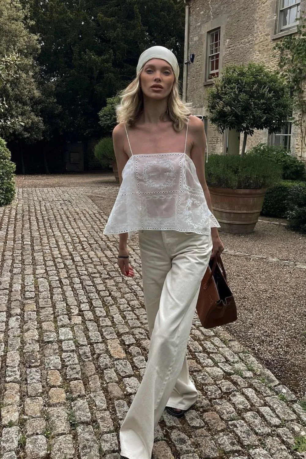 woman walking in a white shirt and wide leg pants