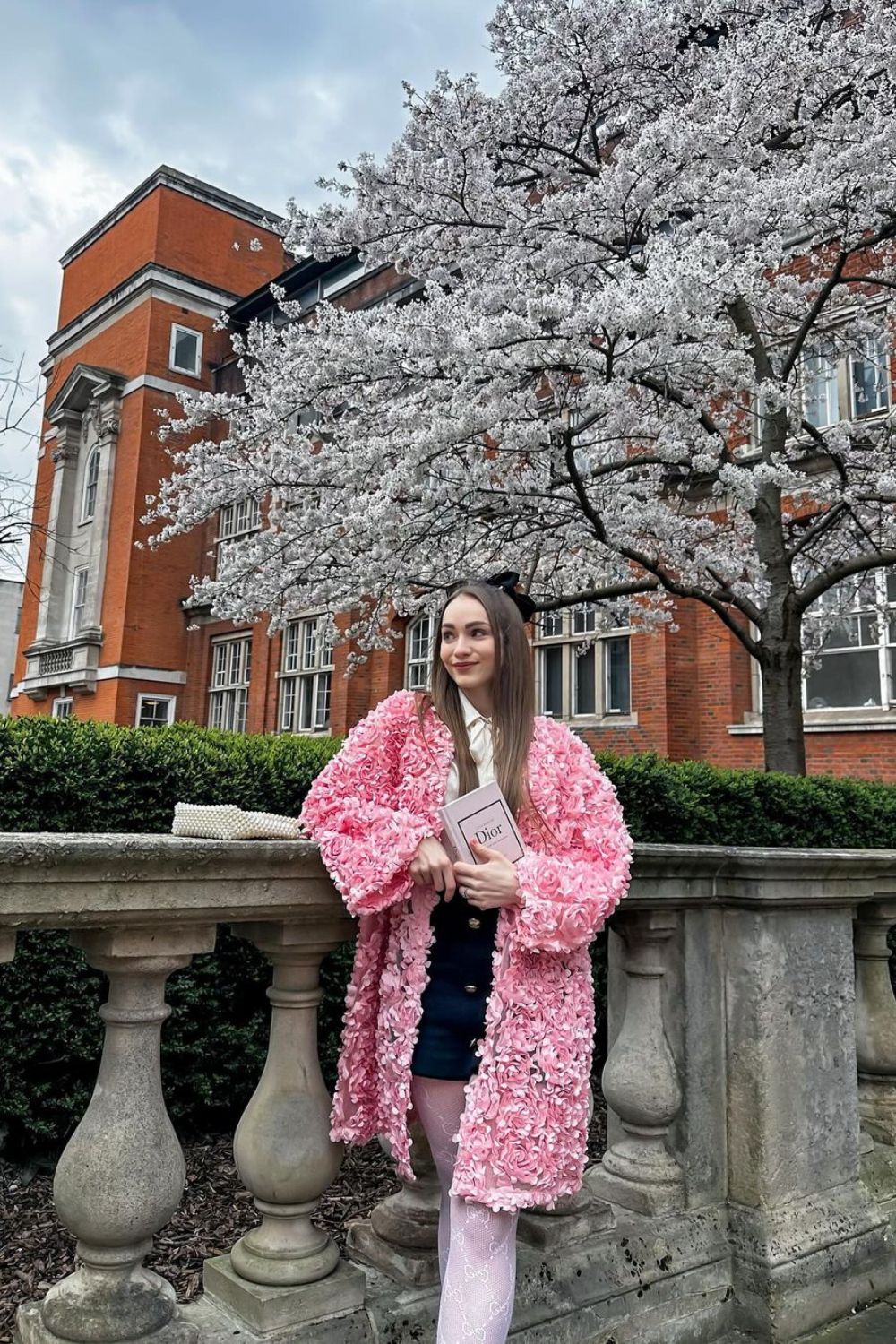 young woman posing in a pink coat