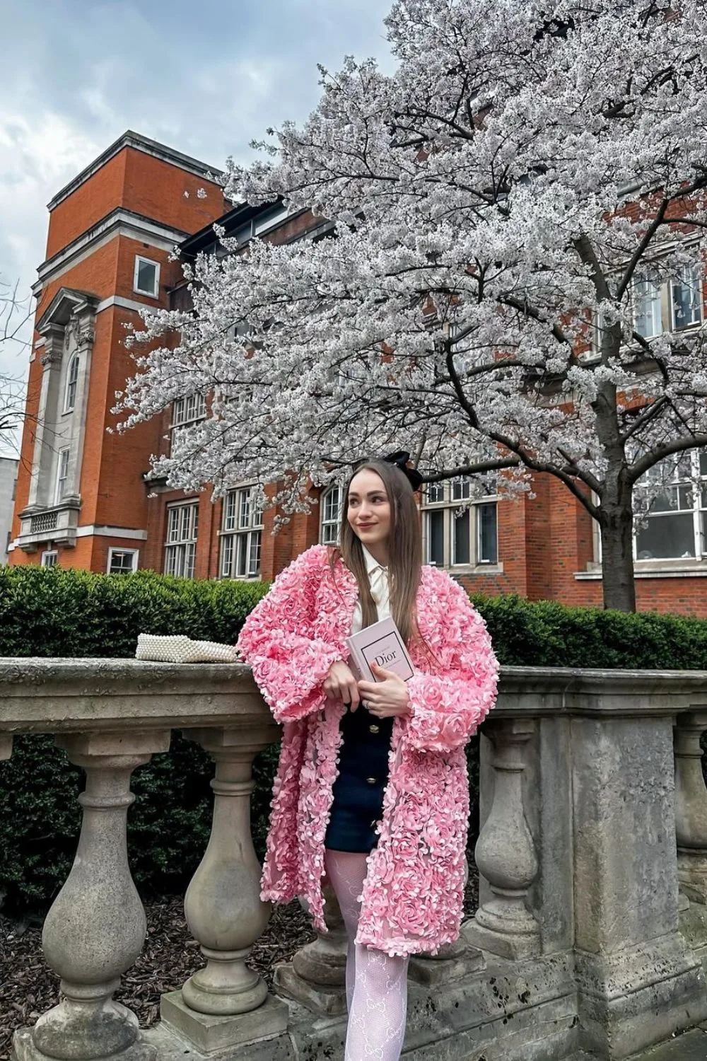 young woman posing in a pink coat