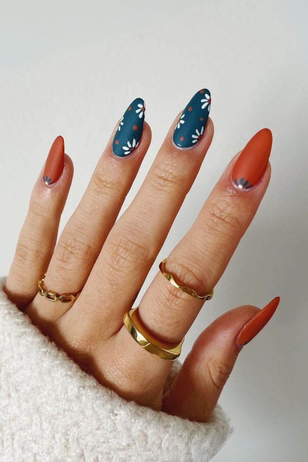 Burnt orange and blue nails with floral accents