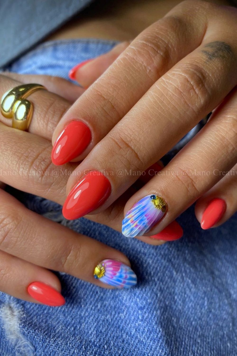 Coral red nails with blue seashell accent