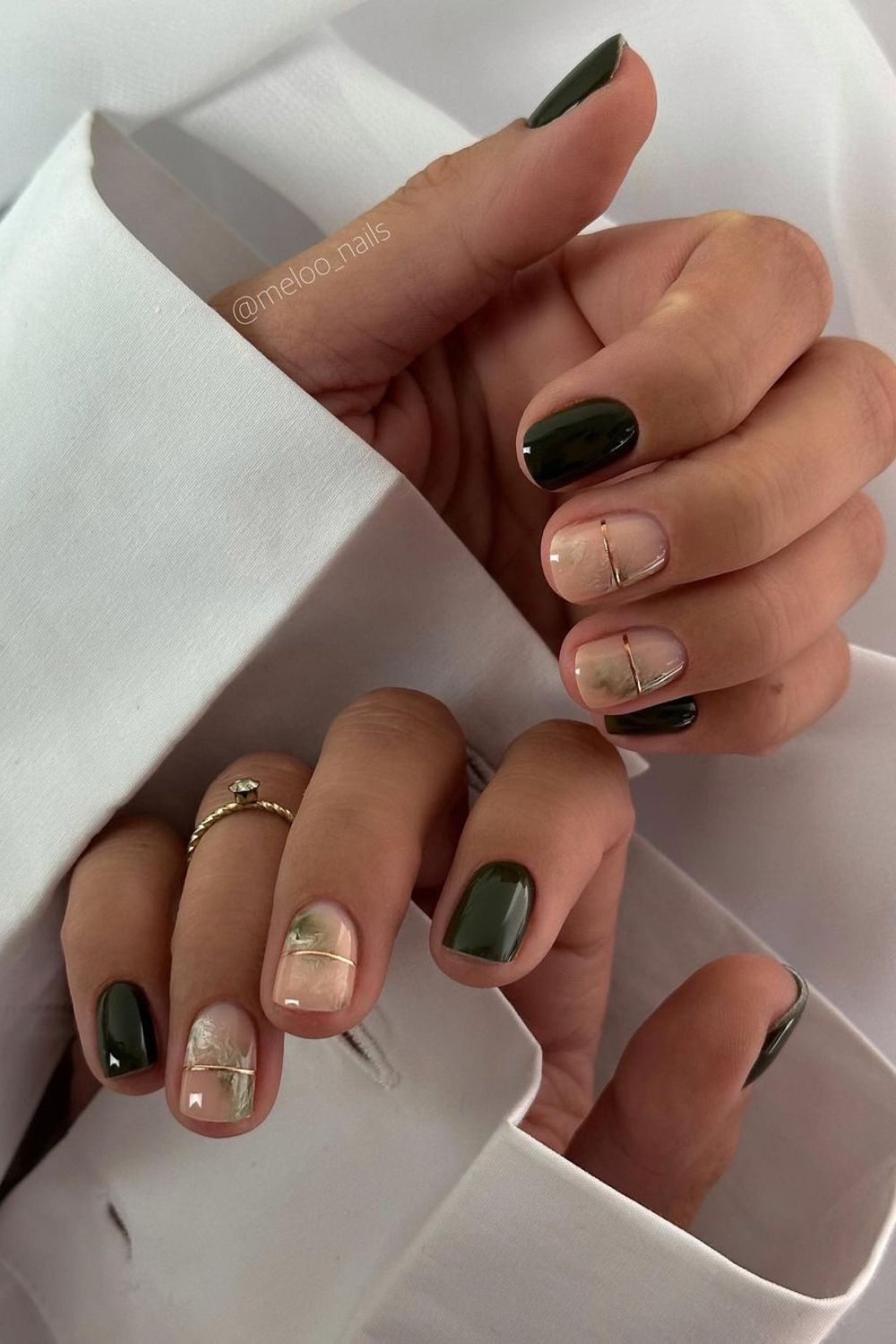 Dark green nails with gold chrome lines