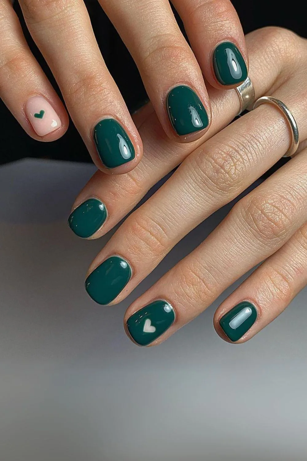 Dark green nails with heart accents