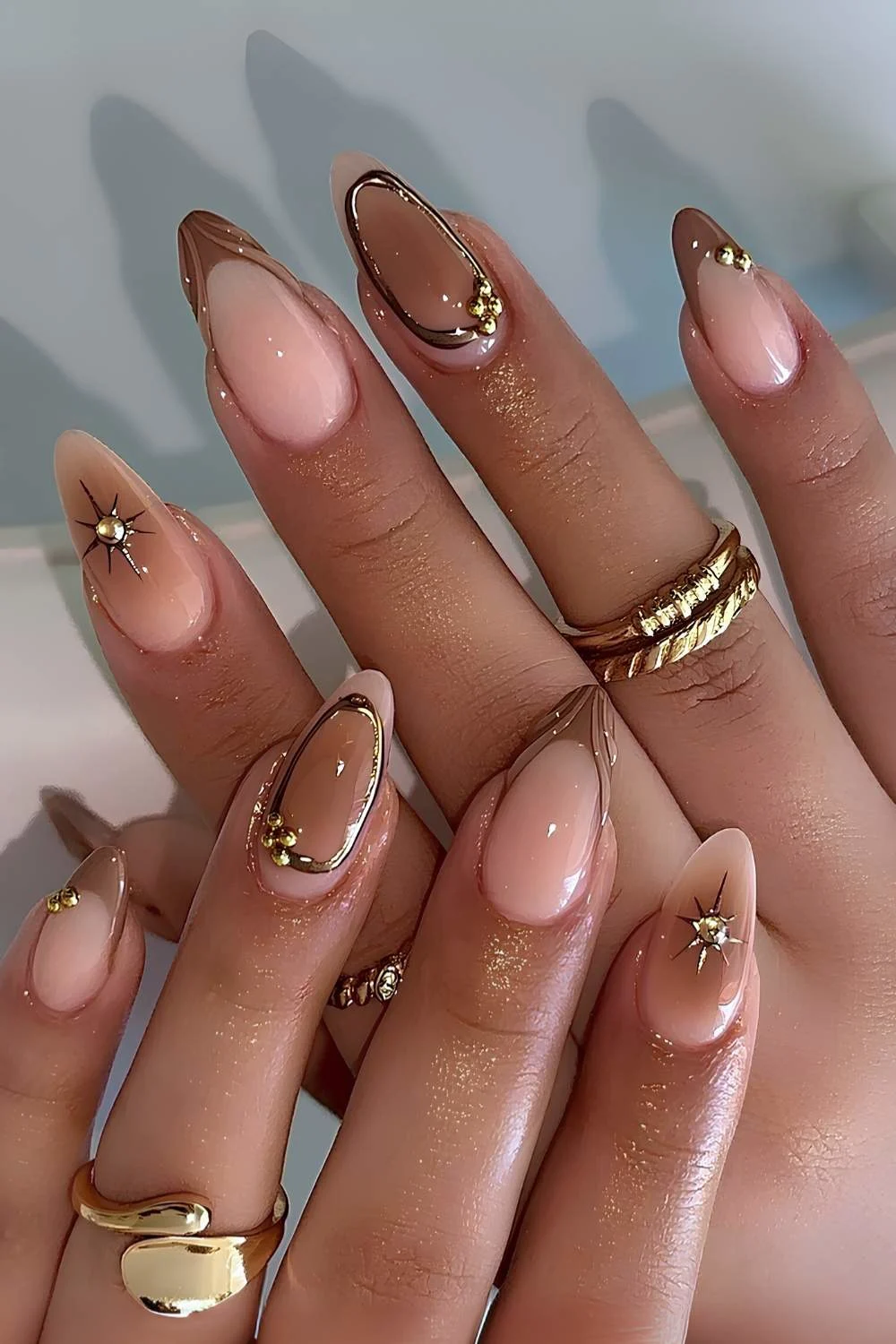 Light brown French mani with gold and aura accents