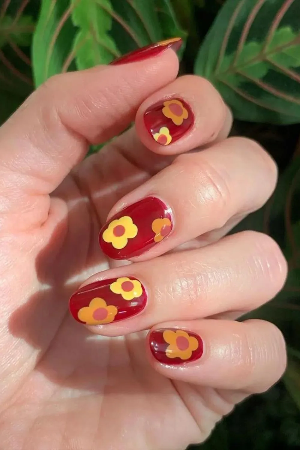 Maroon red nails with bold flowers