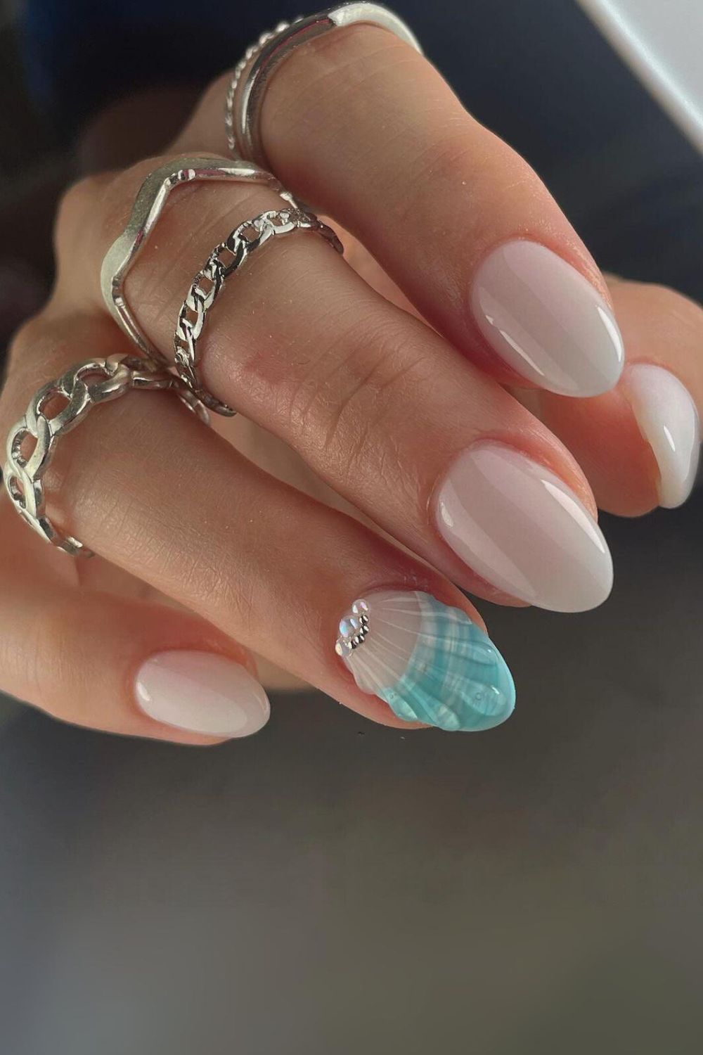 Milky white nails with blue seashell accent