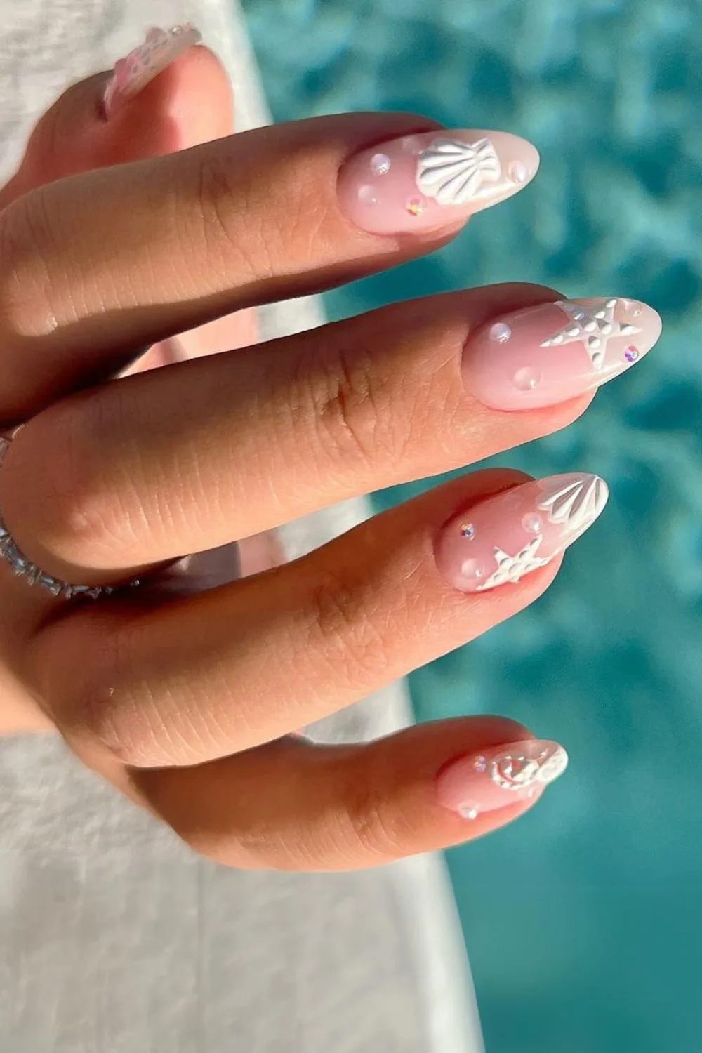 Soft pink nails with 3d white seashells