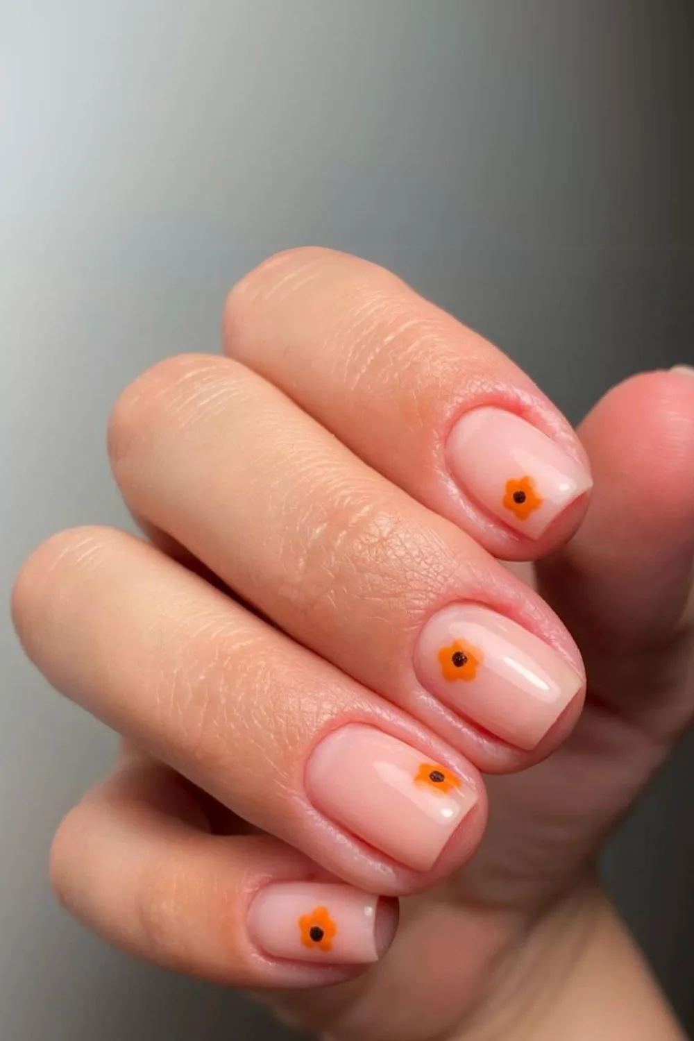 Nude nails with orange flowers