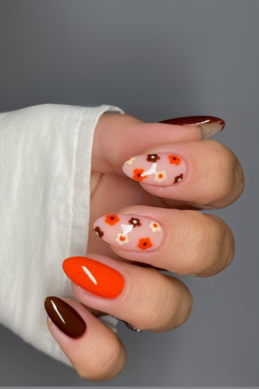 Orange and brown nails with floral accents