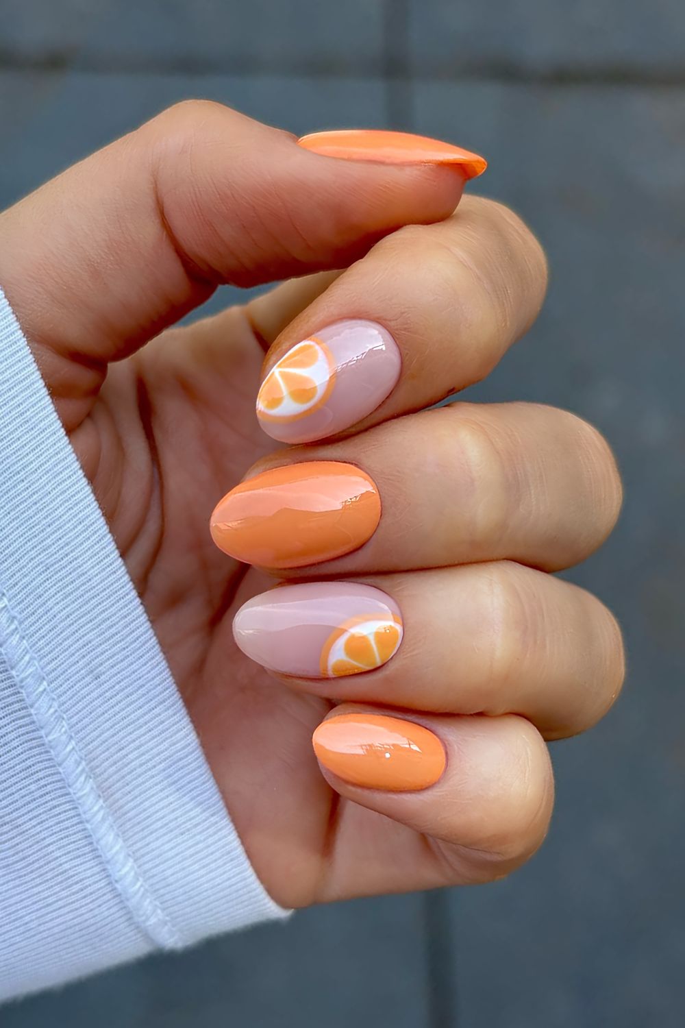 Orange and milky pink nails with orange slice accents