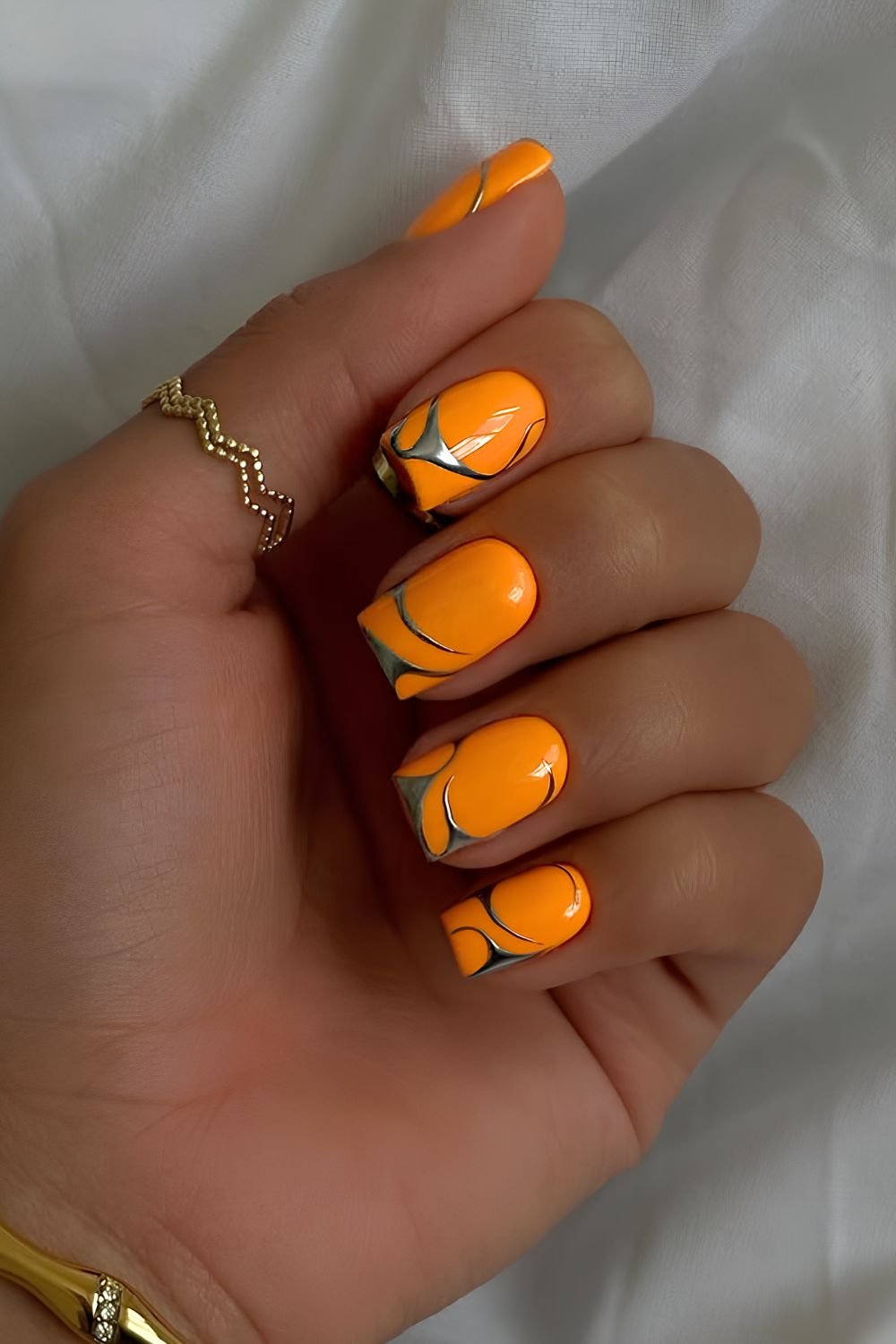 Orange nails with silver chrome accents