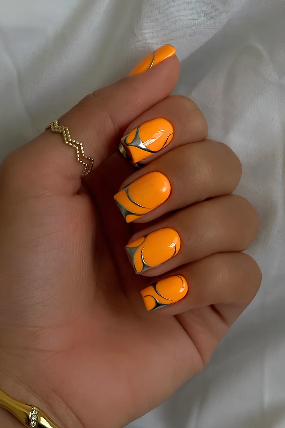 Orange nails with silver chrome accents