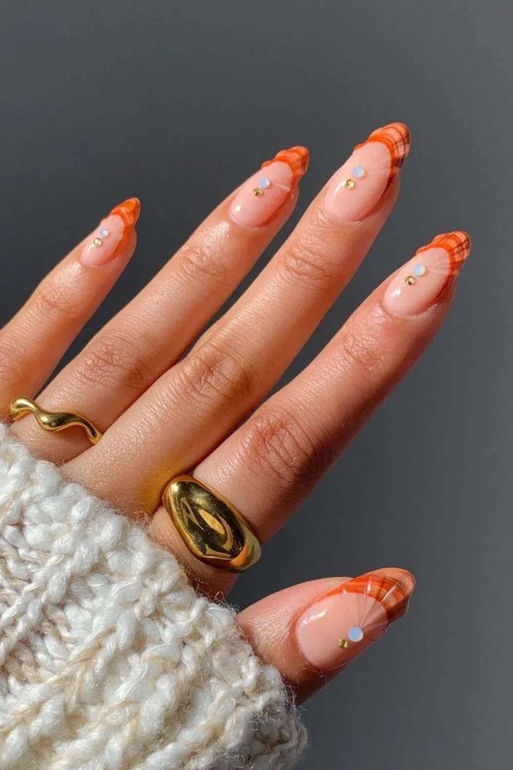 Nude nails with orange seashell tips