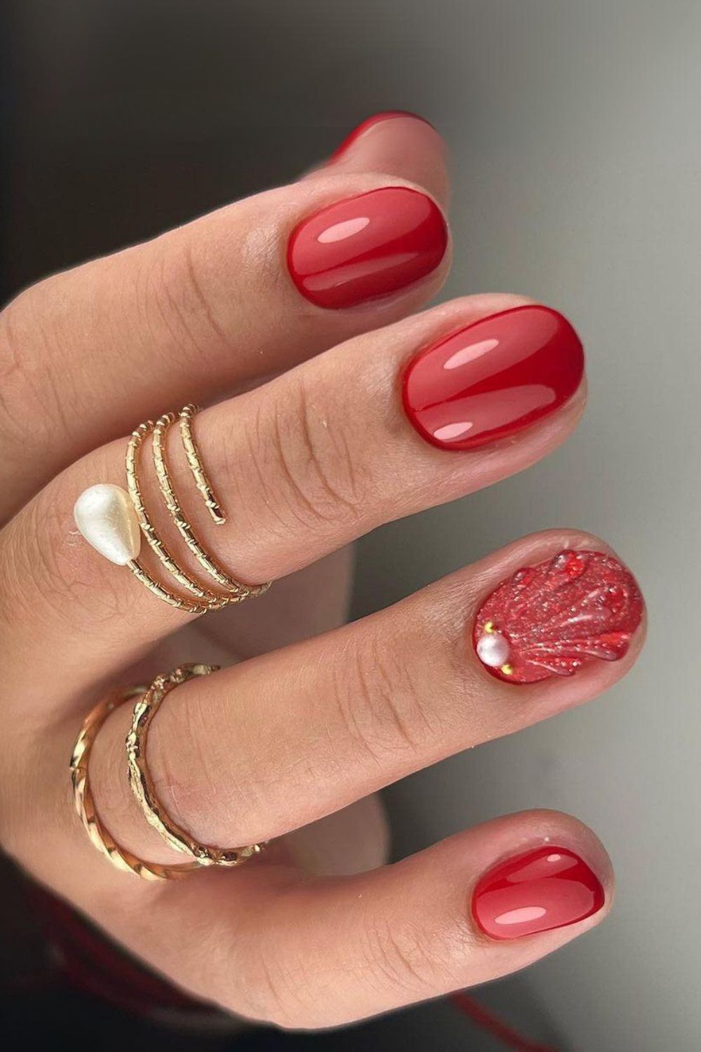 Red nails with glitter seashell accent