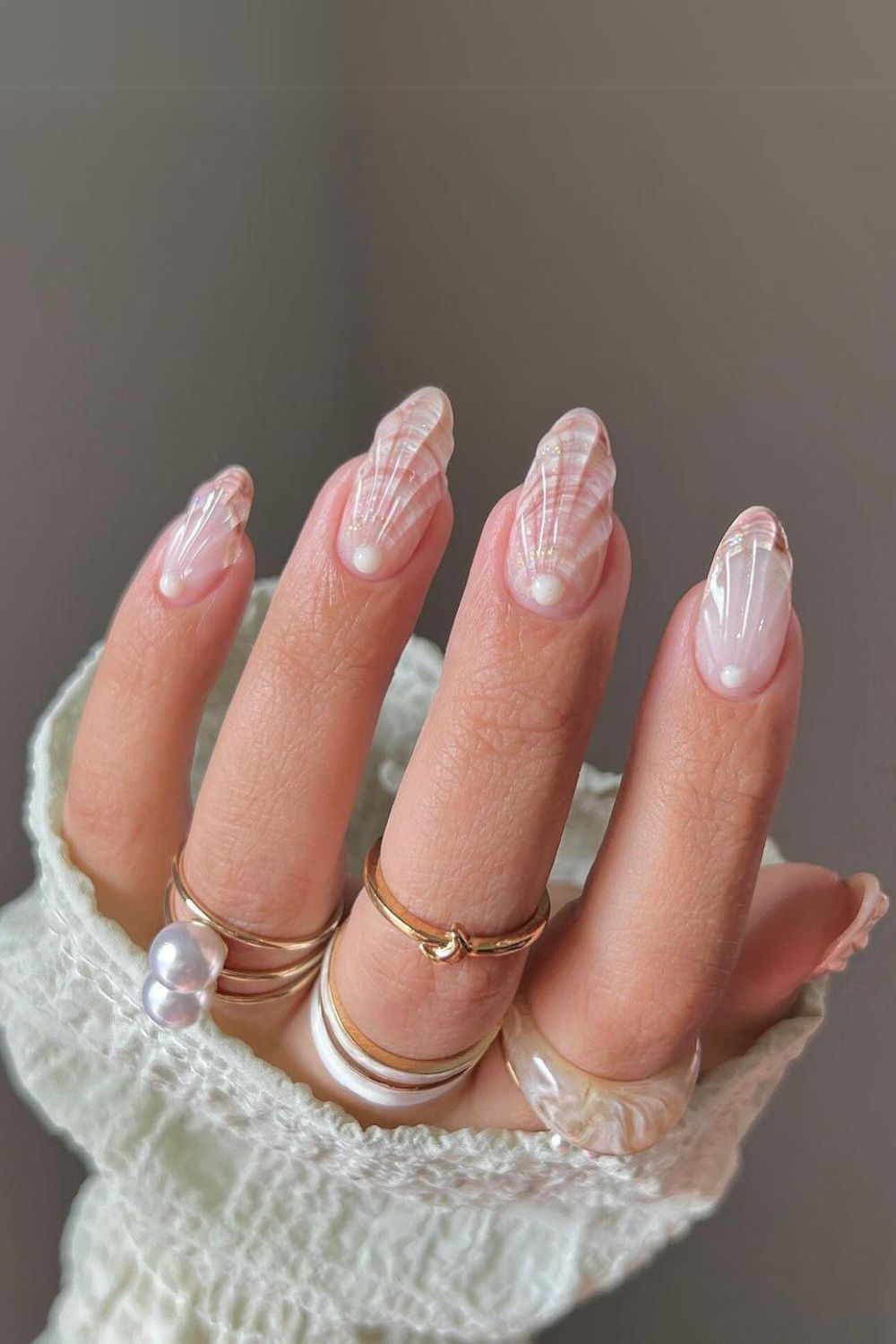 Nails with seashell pattern and pearl accent