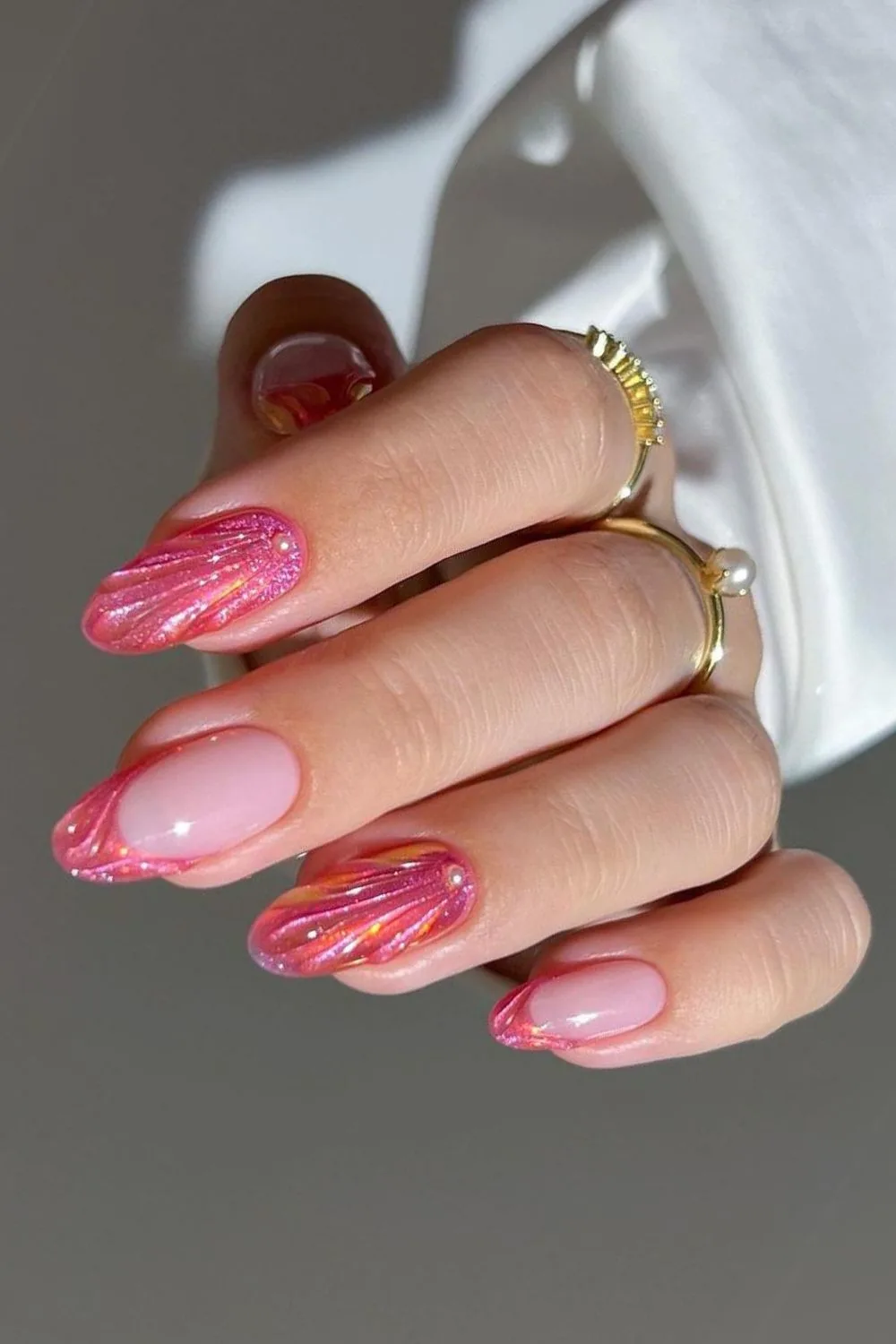 Shimmery coral nails with seashell pattern