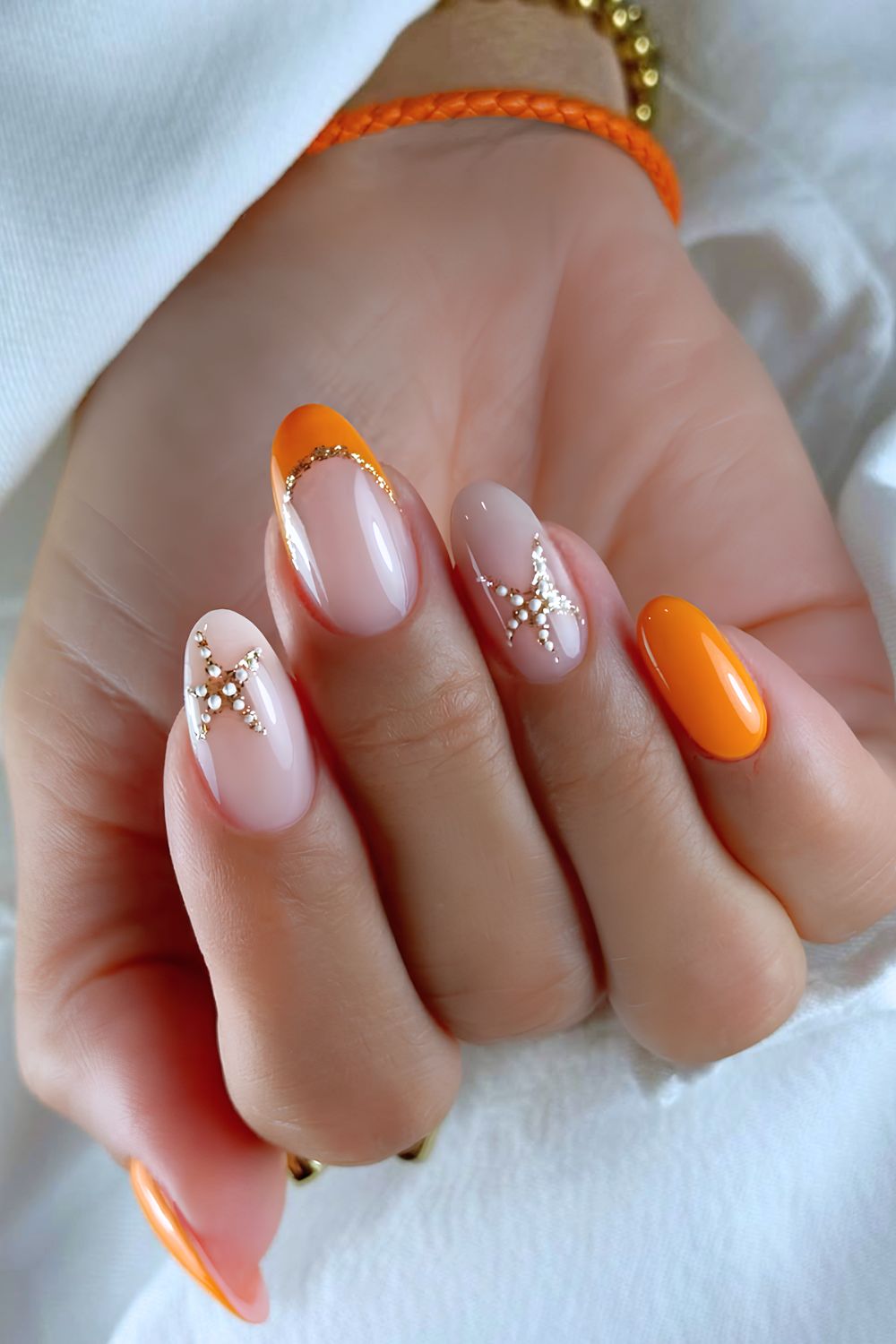 Tangerine orange and milky nails with gold starfish accents