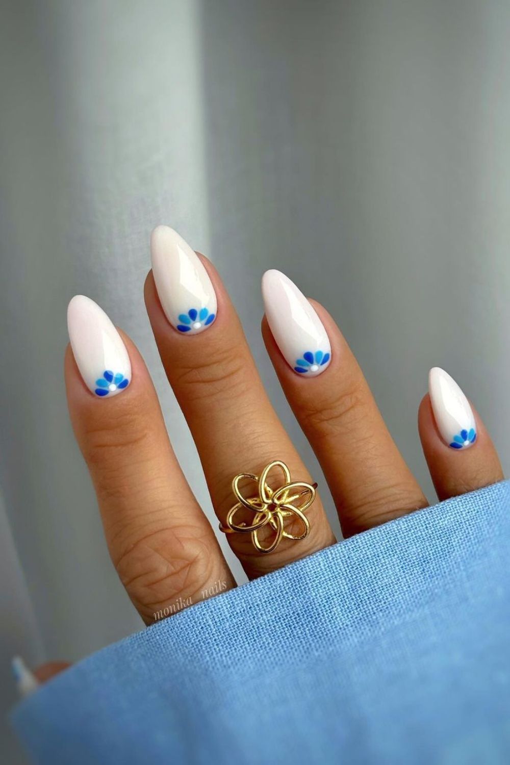 White nails with blue half-moon flowers