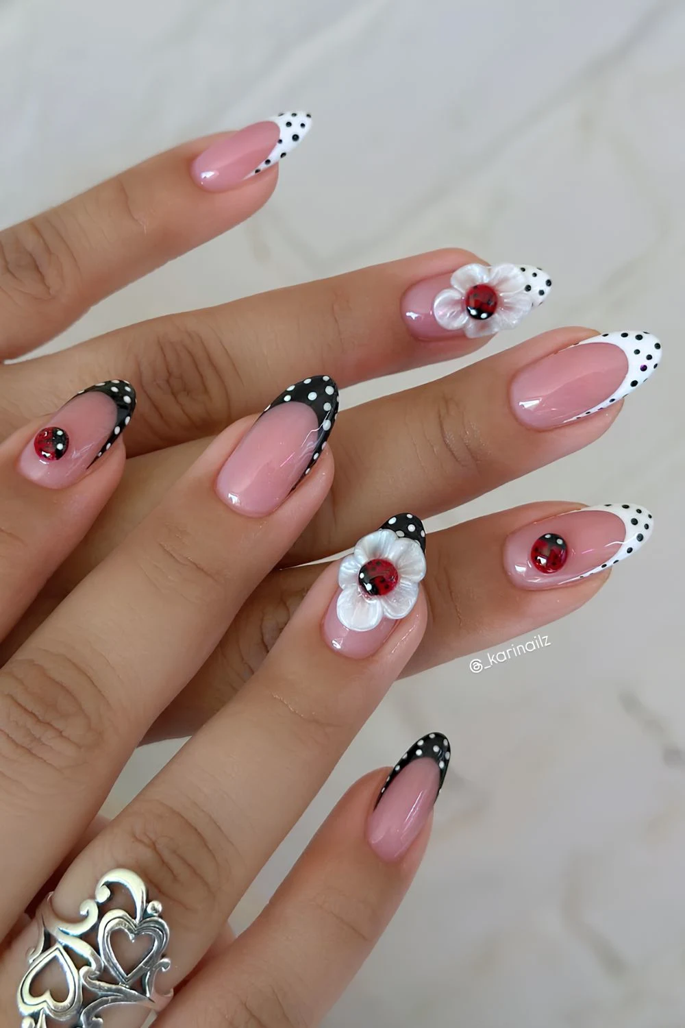 Black and white polka dot nails with lady bug on a sculpted flower design