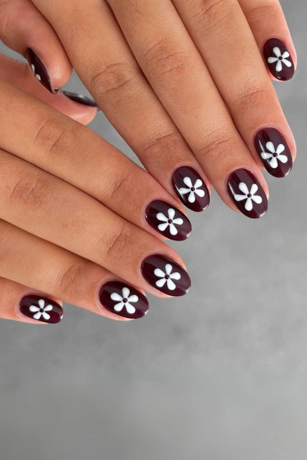 Brown nails with bold daisy accents